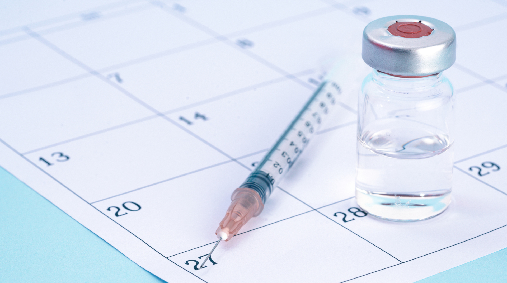 Syringe and Vaccine on a Calendar stock photo