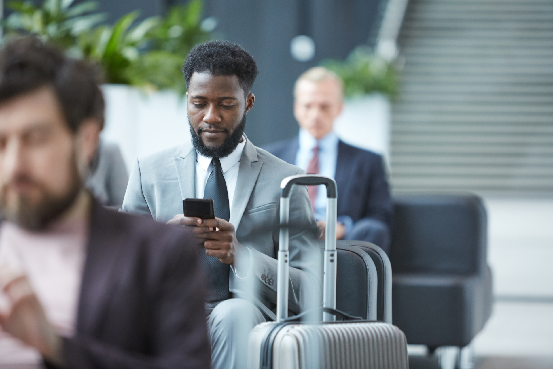 Businessman With Smartphone In Departure Lounge